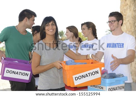 Charity: Happy group of volunteers collecting clothing donations