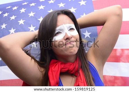 American woman Latin descent, disappointed with flag of United States of America in the background ground