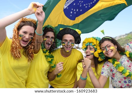 Group Of Happy Brazilian Soccer Fans Commemorating Victory, With The Flag Of Brazil Swinging In The Air.