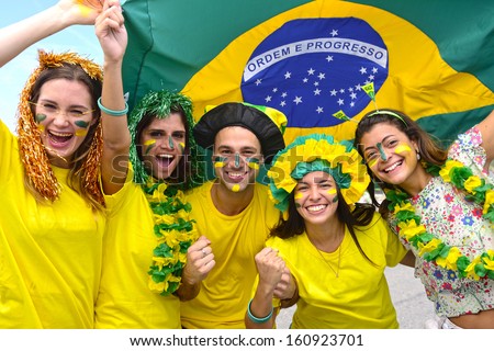Group Of Happy Brazilian Soccer Fans Commemorating Victory,With The Flag Of Brazil Swinging In The Air.