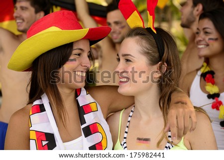 German girls friends soccer fans celebrating victory.
