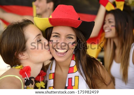 German couple of soccer sport fans kiss celebrating victory.