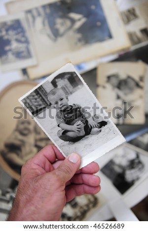 remembering childhood:  man holding photo of himself as a boy