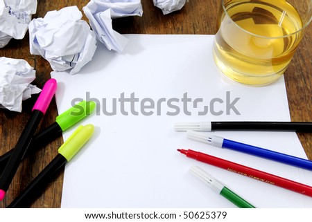 creativity problems: blank paper on desk with many paperballs  and whiskey