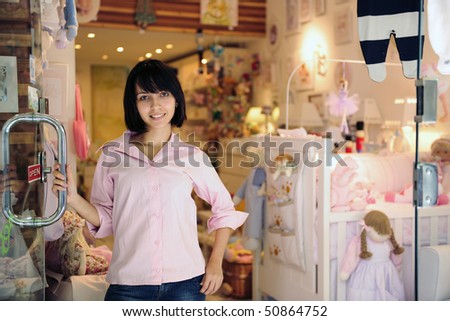 portrait of small business owner: proud woman opening her baby store