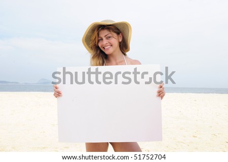 Advertising on the beach: woman showing blank board with copy space for your ad