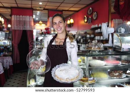 small business: happy waitress showing a tasty cake