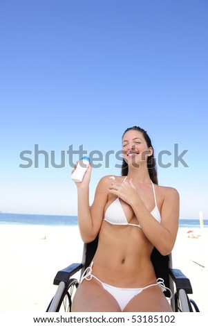 summer vacation: woman in wheelchair applying sunscreen on the  beach