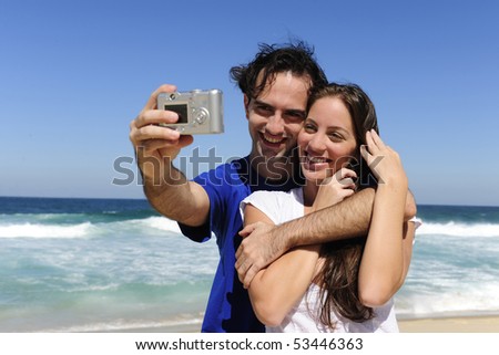 summer vacation: couple taking a photo with a digital compact camera