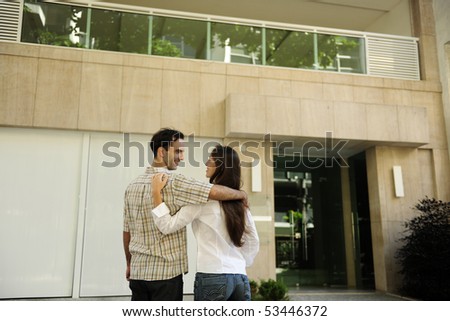 Renting or buying an apartment: Couple standing in front of their new flat