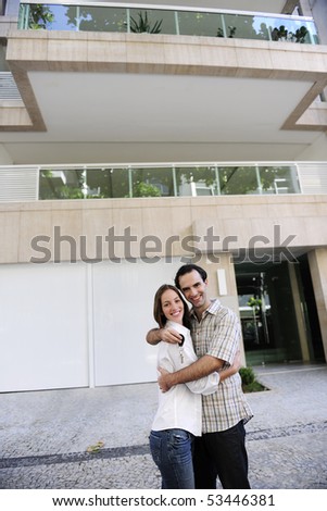 Renting or buying an apartment: Couple standing in front of their new flat