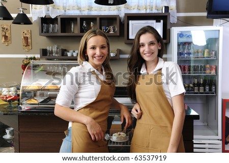 Two happy waitresses working at a cafe
