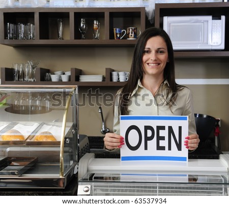 Small business: Happy owner of a cafe showing open sign