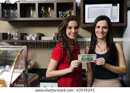 Small business: Owners of a cafe holding cash and smiling