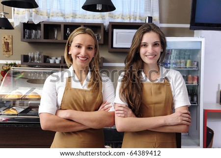 Two happy waitresses working at a cafe