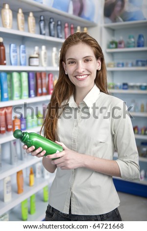 happy woman at pharmacy buying shampoo