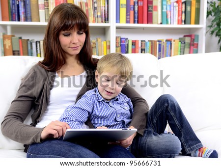 mother and son using tablet with touchscreen together reading an ebook