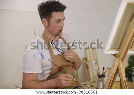male artist painting female model at art studio