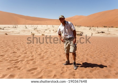 SOSSUSVLEI, NAMIBIA - NOVEMBER 2 2013: Tour Guides continue through the Dead Vlei in a year that was declared as a drought year by the government in Namibia, Africa