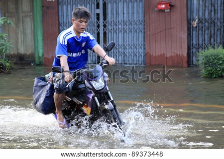 BANGKOK, THAILAND - NOVEMBER 17 : Motorbike navigates the floods after the heaviest rains in 20 years in Thailand on Nov 17, 2011 in Bangkok, Thailand