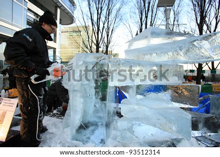 LONDON, UK - JANUARY 13 : Man cuts through ice sculpture with a  chainsaw at the International Ice Sculpting Festival  in London on January 13th, 2012