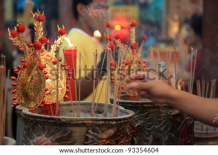 BANGKOK - JANUARY 23 : Chinese New Year 2012 - Man places incense stick in temple in Chinatown, Bangkok, Thailand. 23 Jan 2012