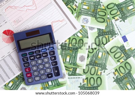 calculator and a report with graphics and statistics on a background with 100 euros banknotes