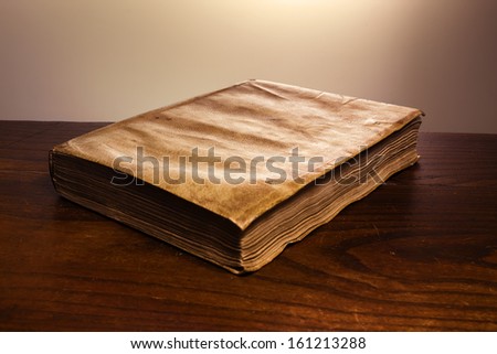 an old grunge book with covers closed up old wooden table