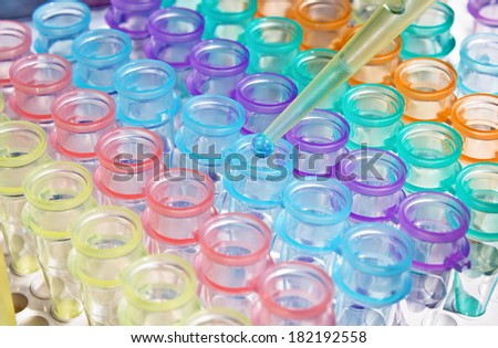 pipette depositing sample in micro tubes at genetic laboratory