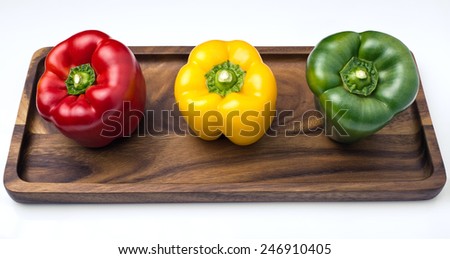 three Bell Peppers of colors shown in tray and isolated on white background / three Bell Peppers, red, yellow and green