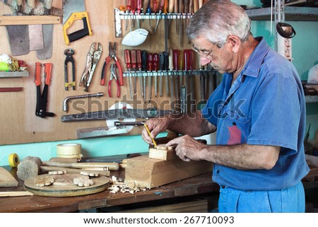 vertical portrait of carpenter marking with pencil handmade pieces of wood workshop / work cabinetmaker marking handcrafted wooden pieces in garage at home