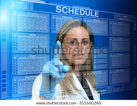 female doctor touching the interface of a virtual application with medical agenda / woman doctor using a virtual touch screen interface with a calendar medical