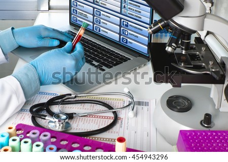 doctor testing blood tube in the laboratory / hands of a scientist holding blood tube sample in hematology lab