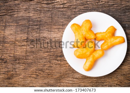 Deep fried dough sticks in white plate on wooden table