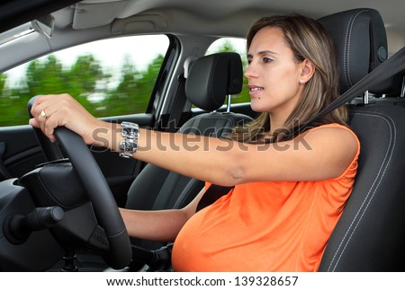 Pregnant Woman Driving a Car Through the Woods