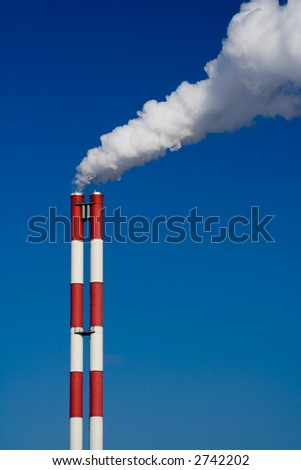 The chimney of a factory with white smoke. Vertical