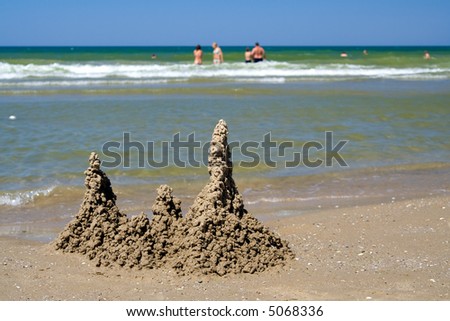 Sand castle and people in the see on the background