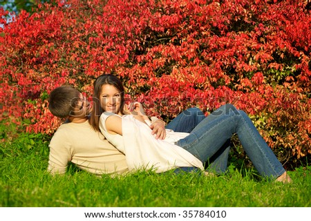 Happy young couple in love meeting in the autumn park with red leaves