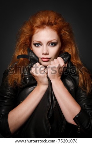 Portrait of beautiful young redhead woman over black
