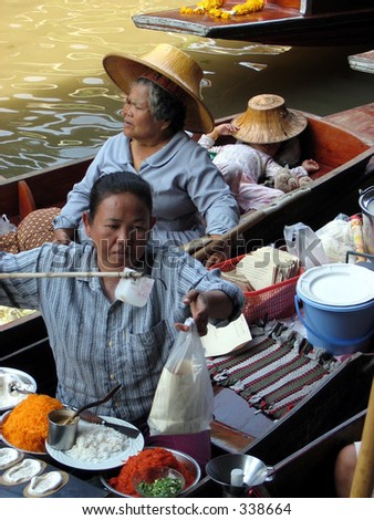 A woman serves food at a Floating Market in Thailand