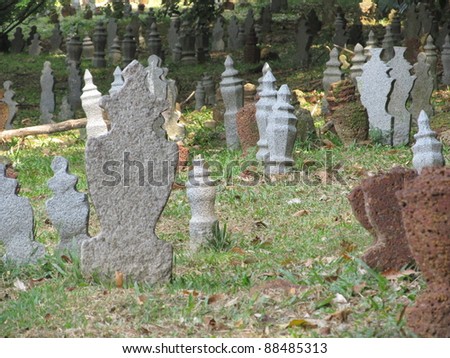 Malaysia, Malacca, Chinese ancient graveyard by the road near St. John\'s Hill. Chinese graveyards are often built on hillsides to maximize positive feng shui. The tomb stones stand like domino pieces.