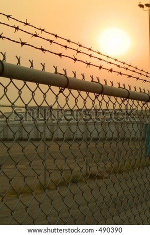 chain link fence with an eerie feeling cast by hazy light from the sun threw an extremely smokey day
