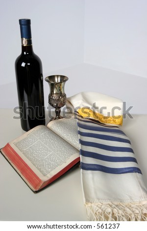Holy Scriptures opened with Talit resting on it Kaddish cup and a bottle of red wine
