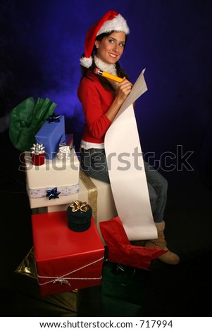 woman in santa hat is double checking her list for the holidays surrounded by gifts in a misty blue background