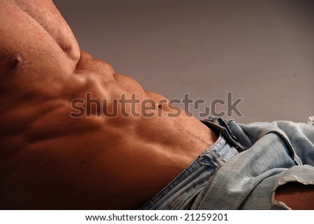 Male bodybuilder sexy abs in jeans laying
