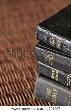 An old stack of Bibles with light reflecting off the spines.