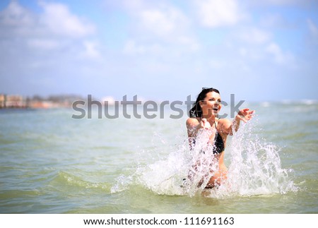 Attractive girl playing in the sea with a splash of watern