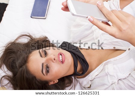 Brunette Young Woman with  Phone in Bed