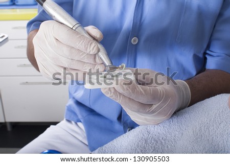 An extreme close-up of a dental patient having their teeth cleaned and polished by the hygieniest.
