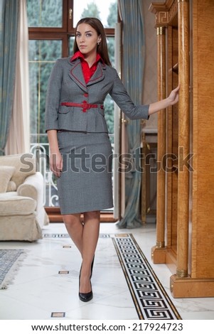 Young business woman standing in living room.